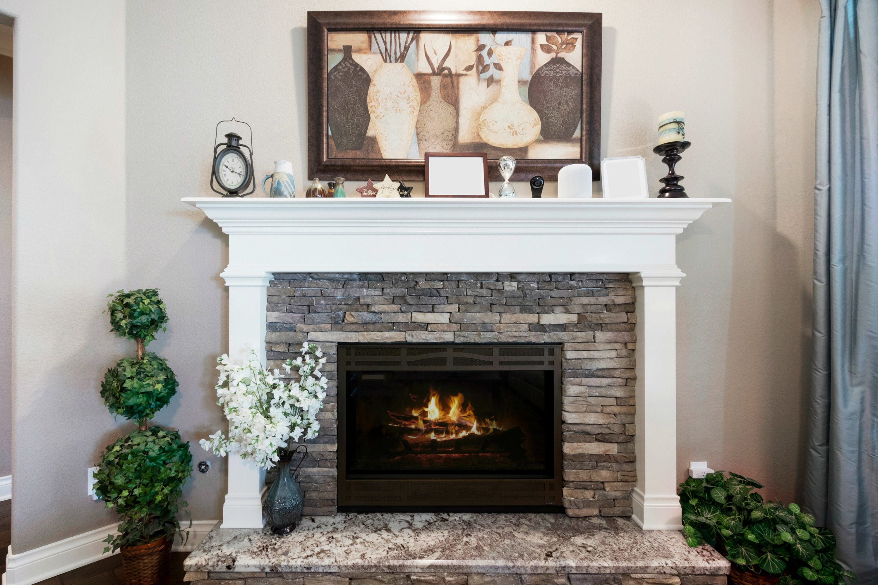 A fireplace with a picture above it and a clock.