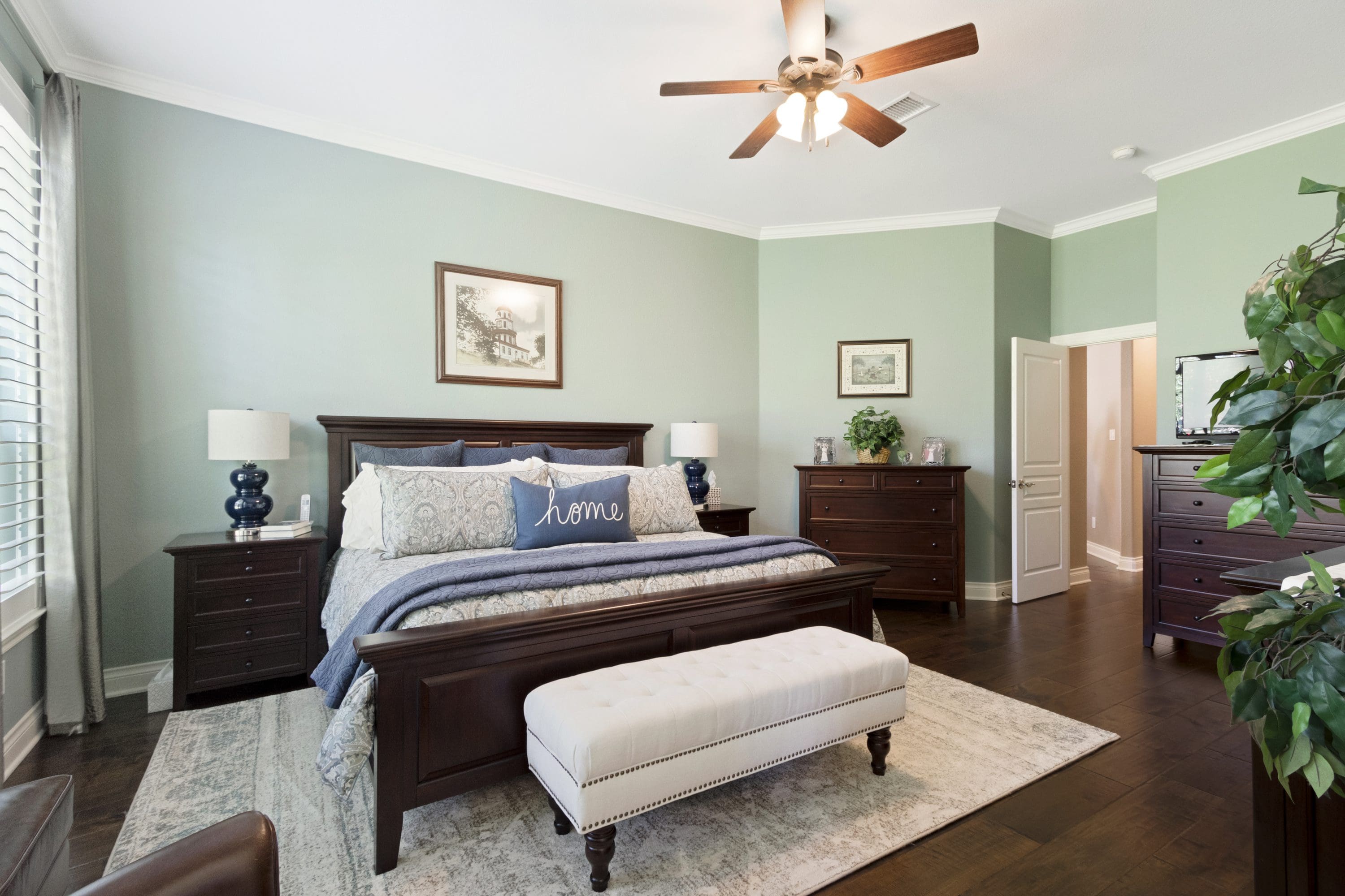 A bedroom with a bed, dresser and nightstand.