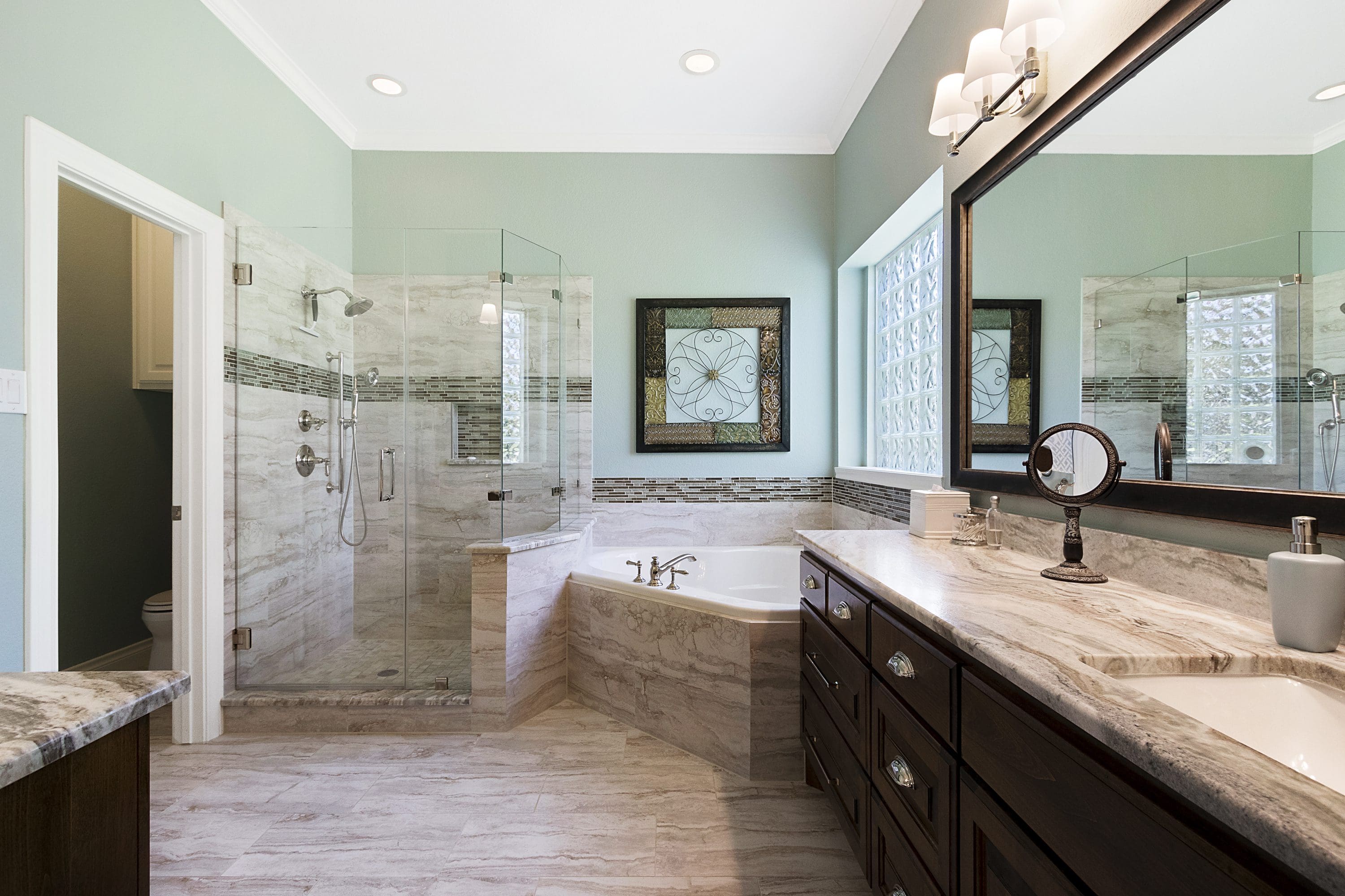 A bathroom with a large mirror and a tub.