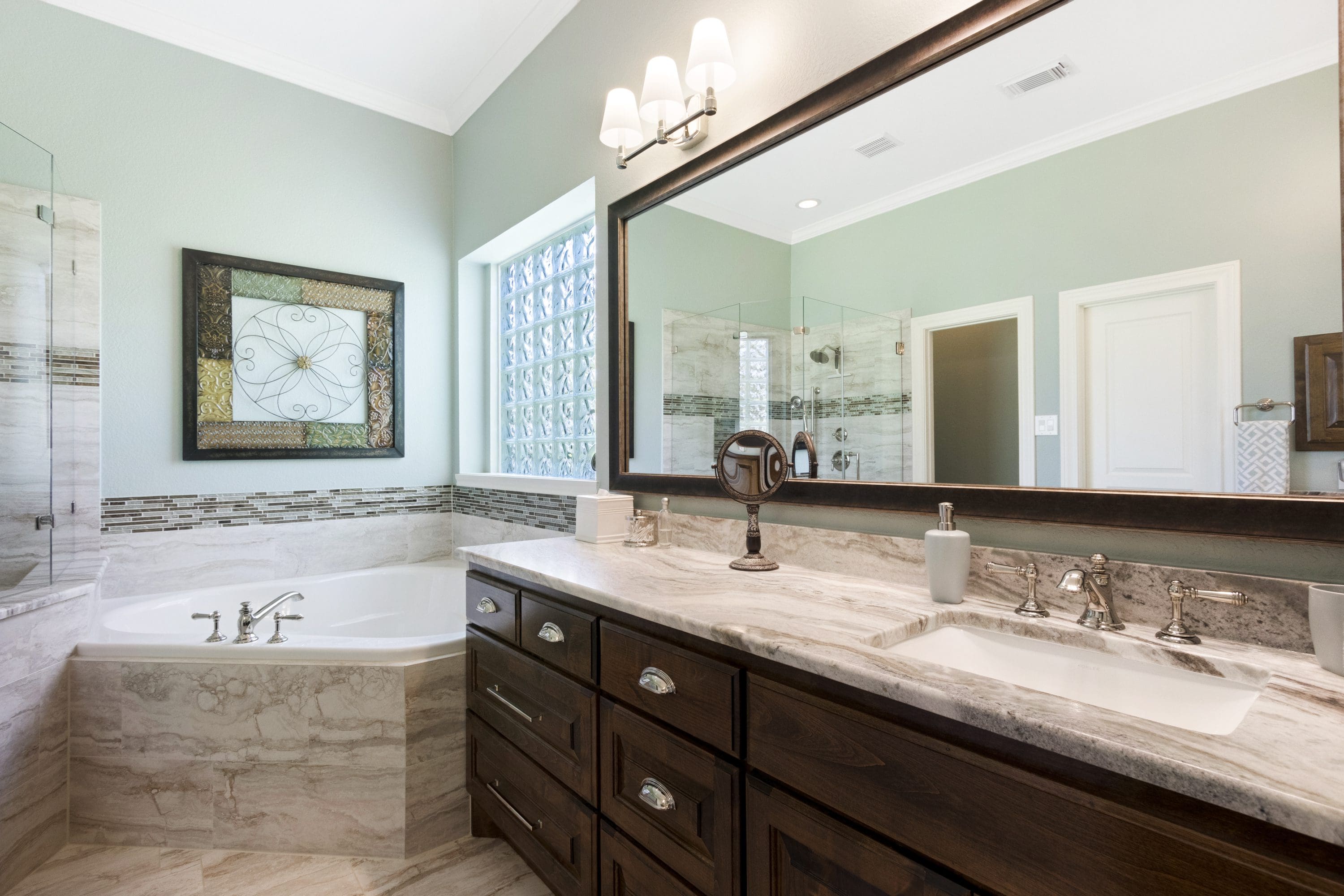 A bathroom with two sinks and a large mirror.