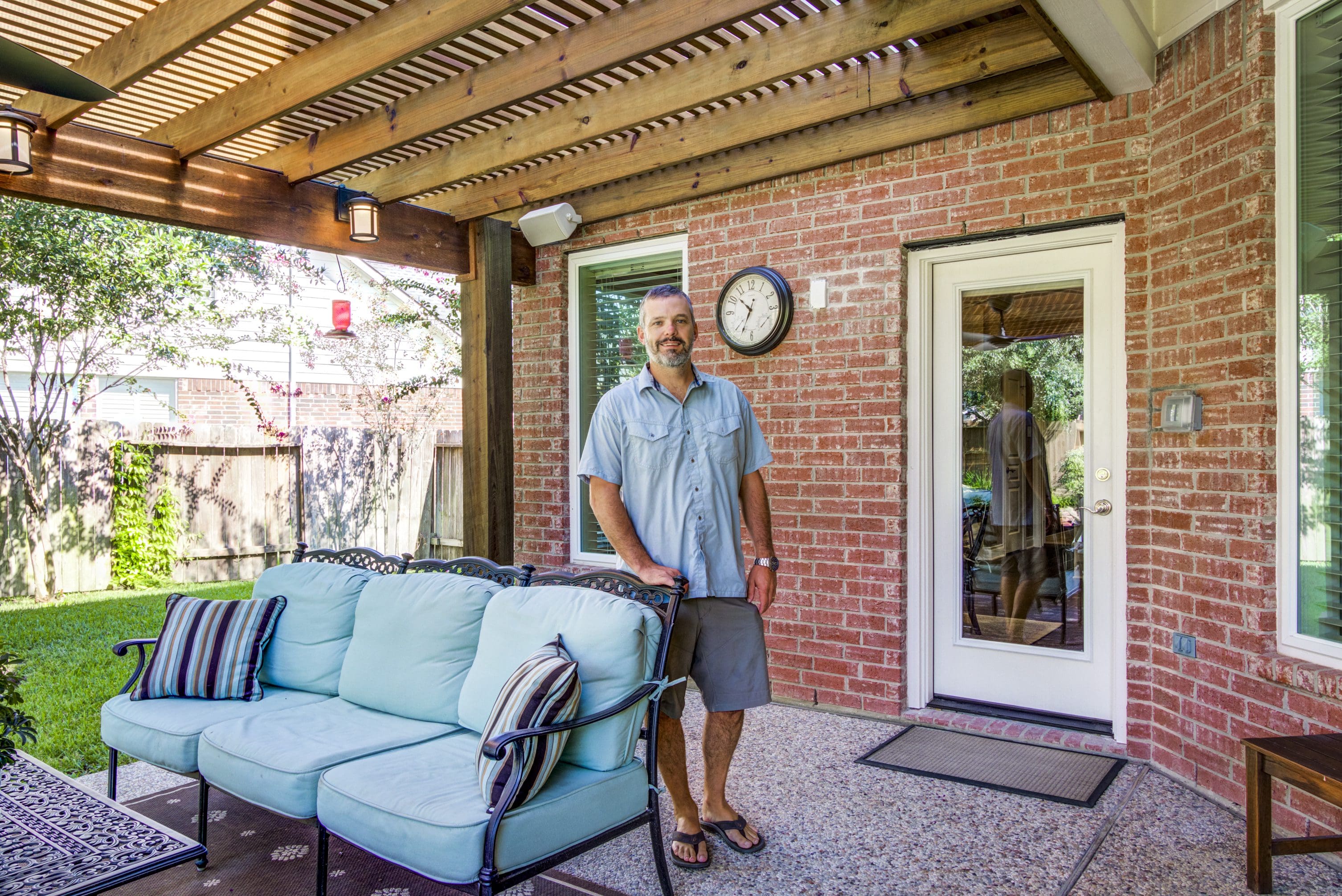 A man standing in front of a couch outside.