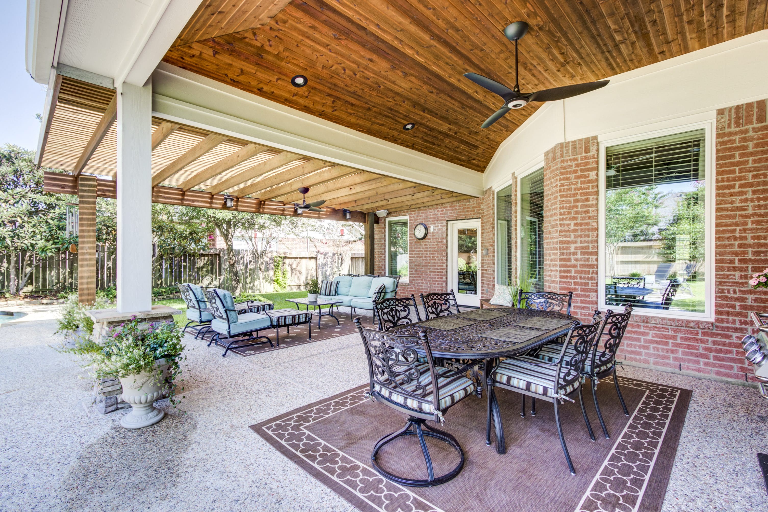 A patio with a table and chairs, covered in rugs.