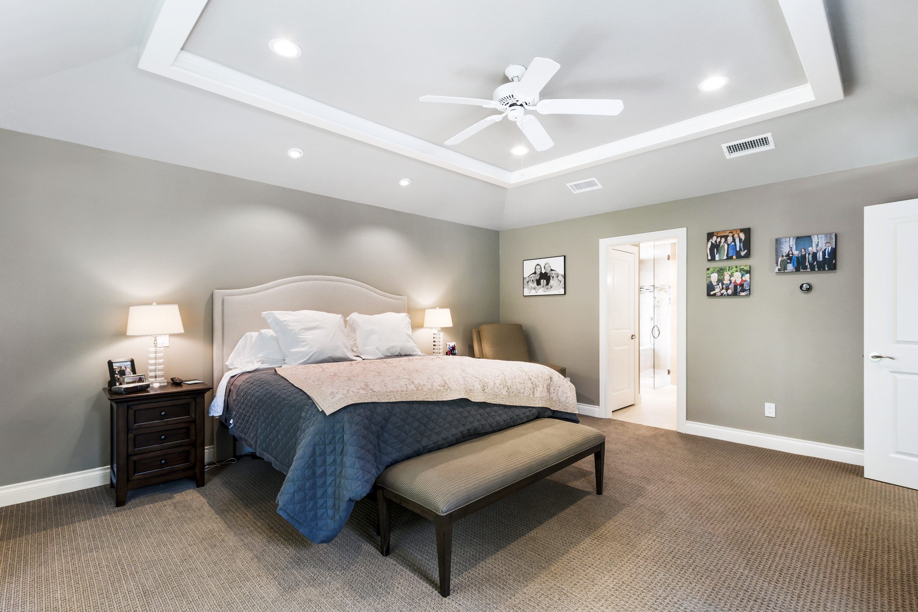 A bedroom with a bed, bench and lights.