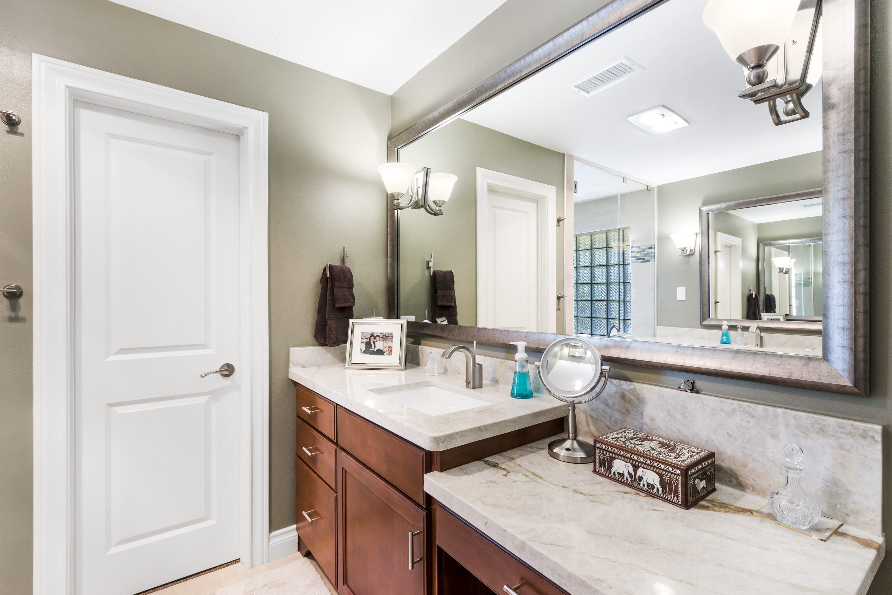 A bathroom with two sinks and a large mirror.