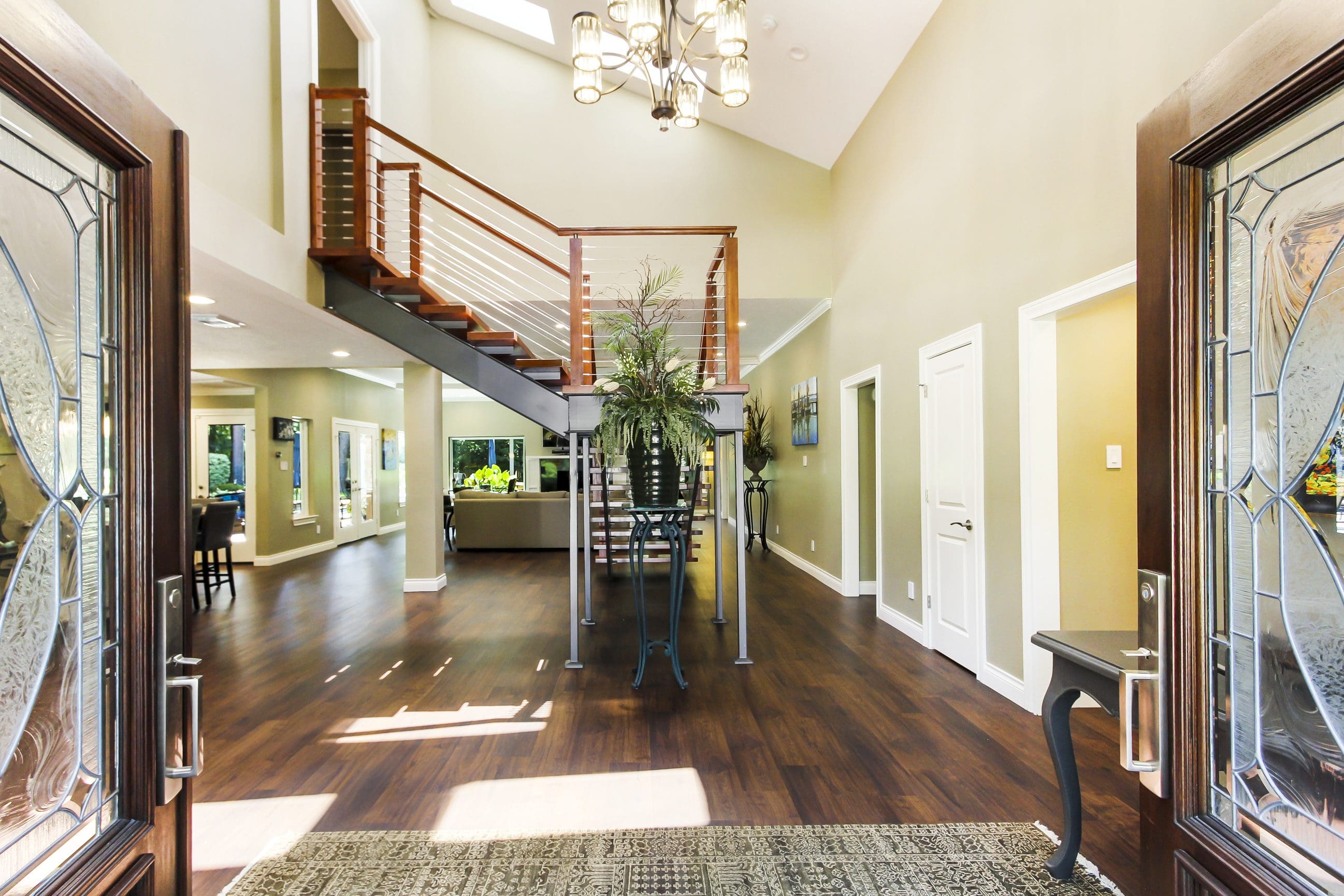 A large open floor plan with a staircase and wood floors.