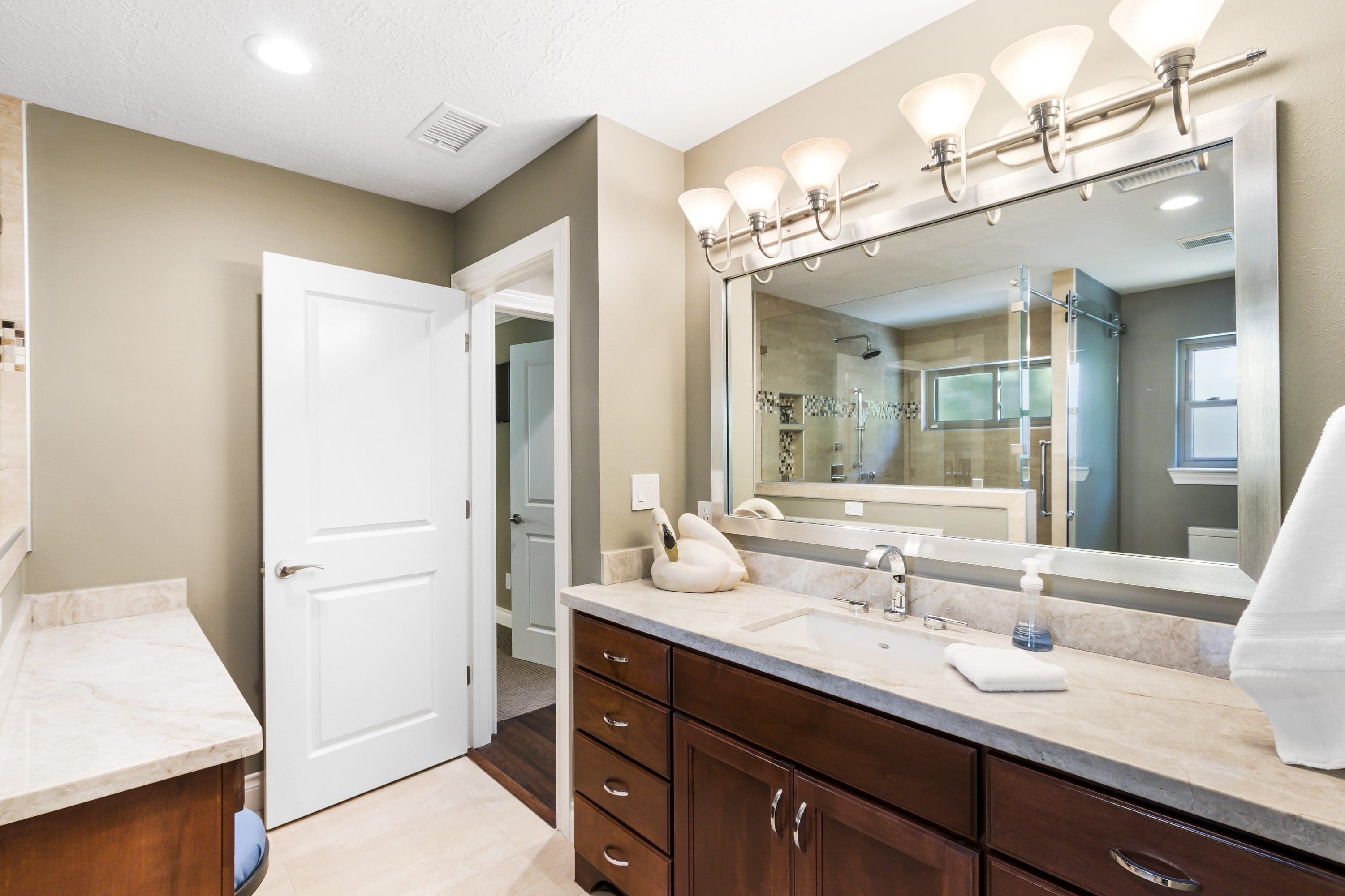 A bathroom with a large mirror and a sink.