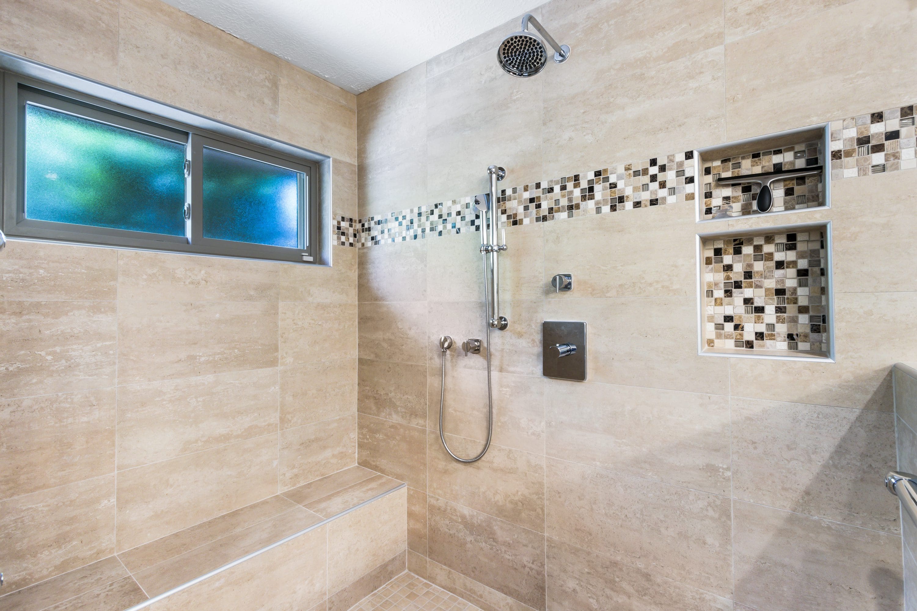 A bathroom with a shower and tiled walls.