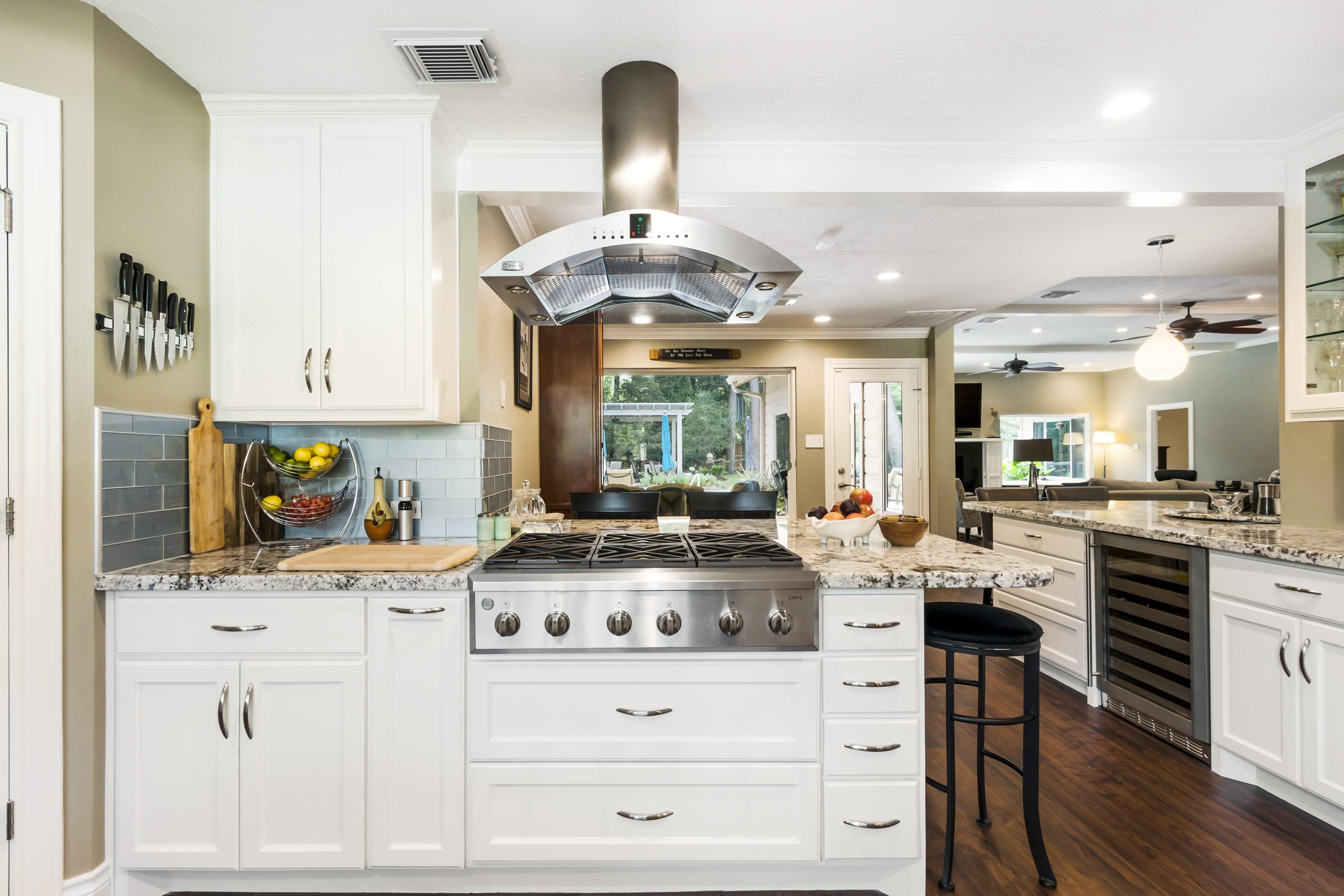 A kitchen with white cabinets and a large island.