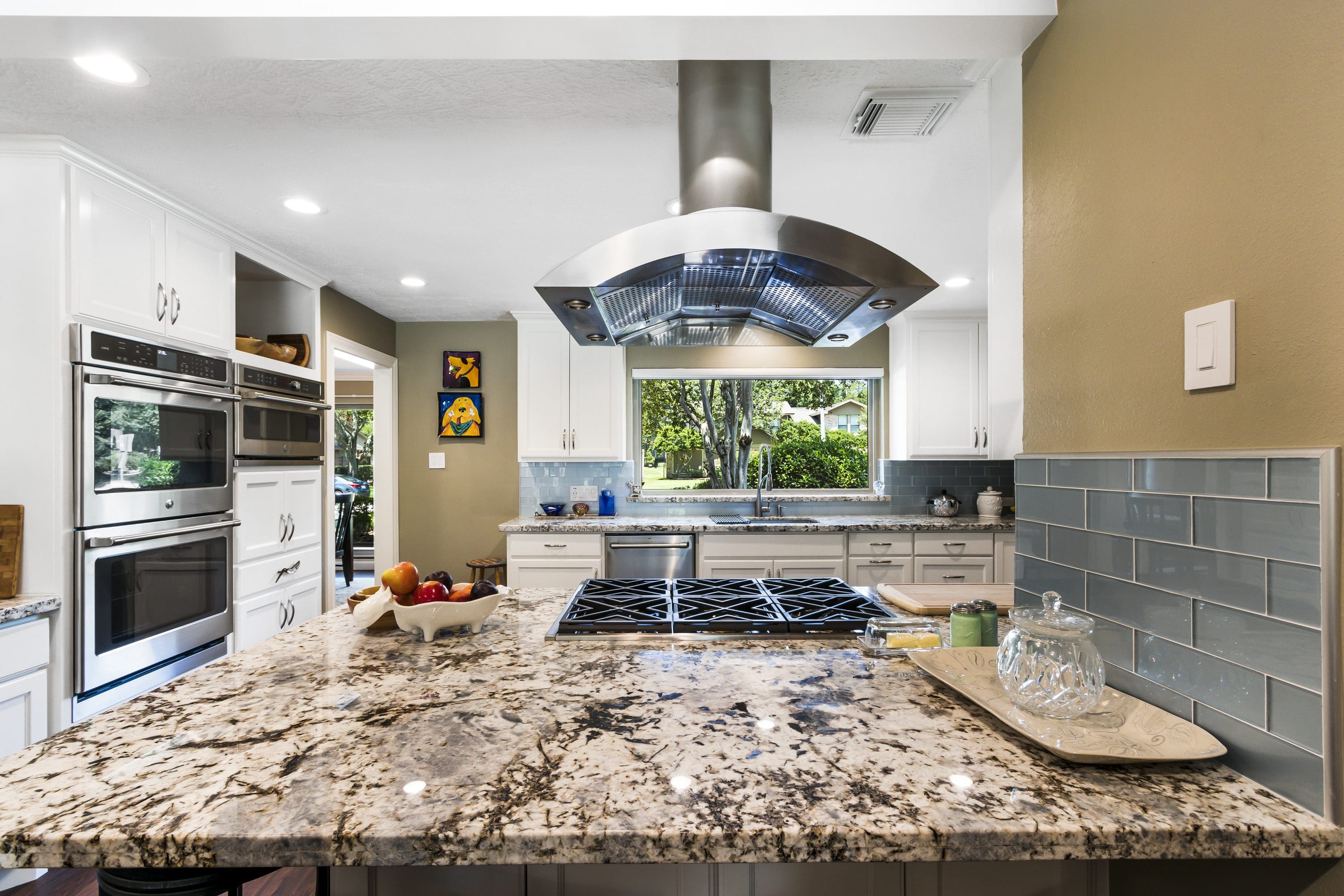 A kitchen with granite counter tops and stainless steel appliances.