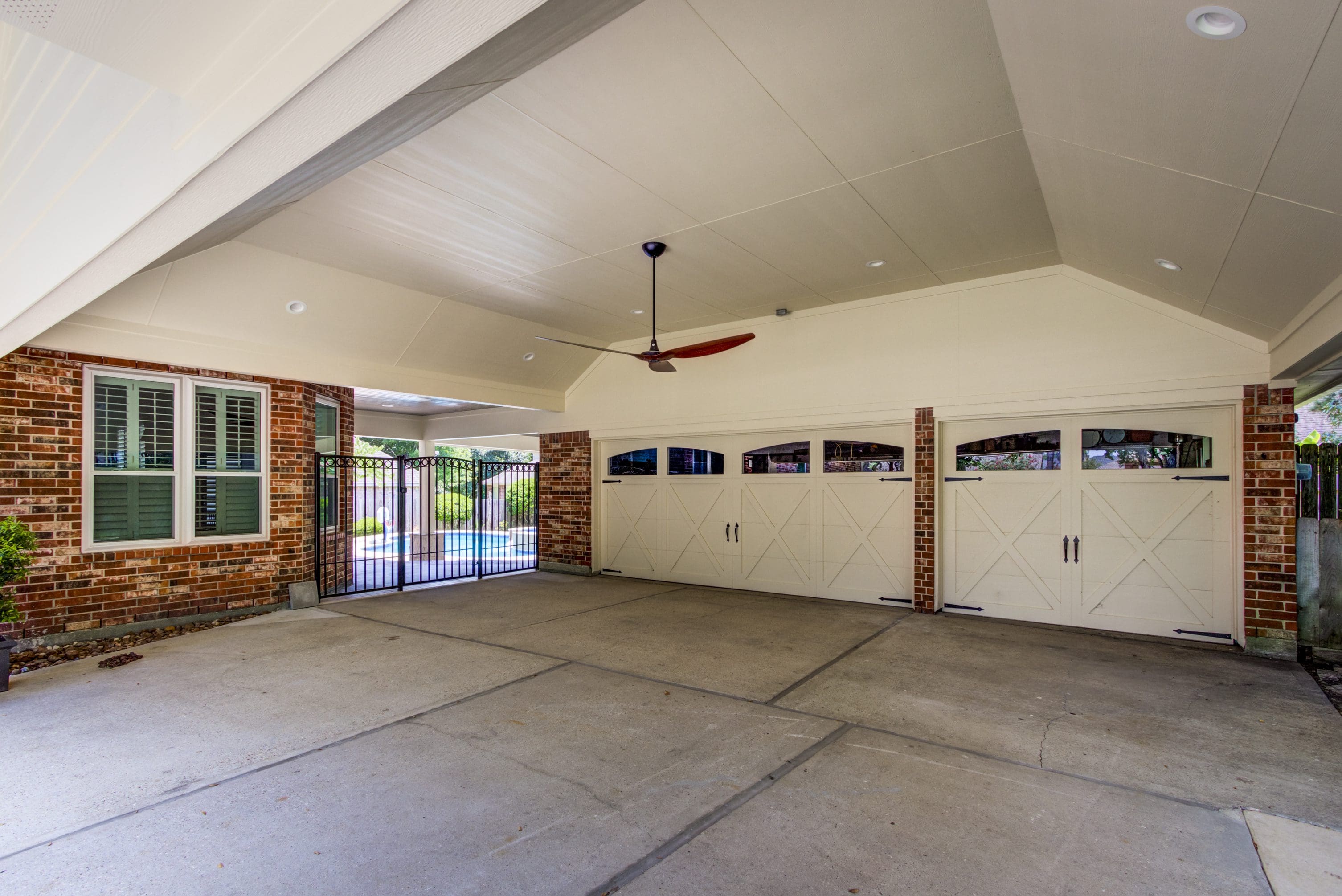 A garage with two doors and a ceiling fan.