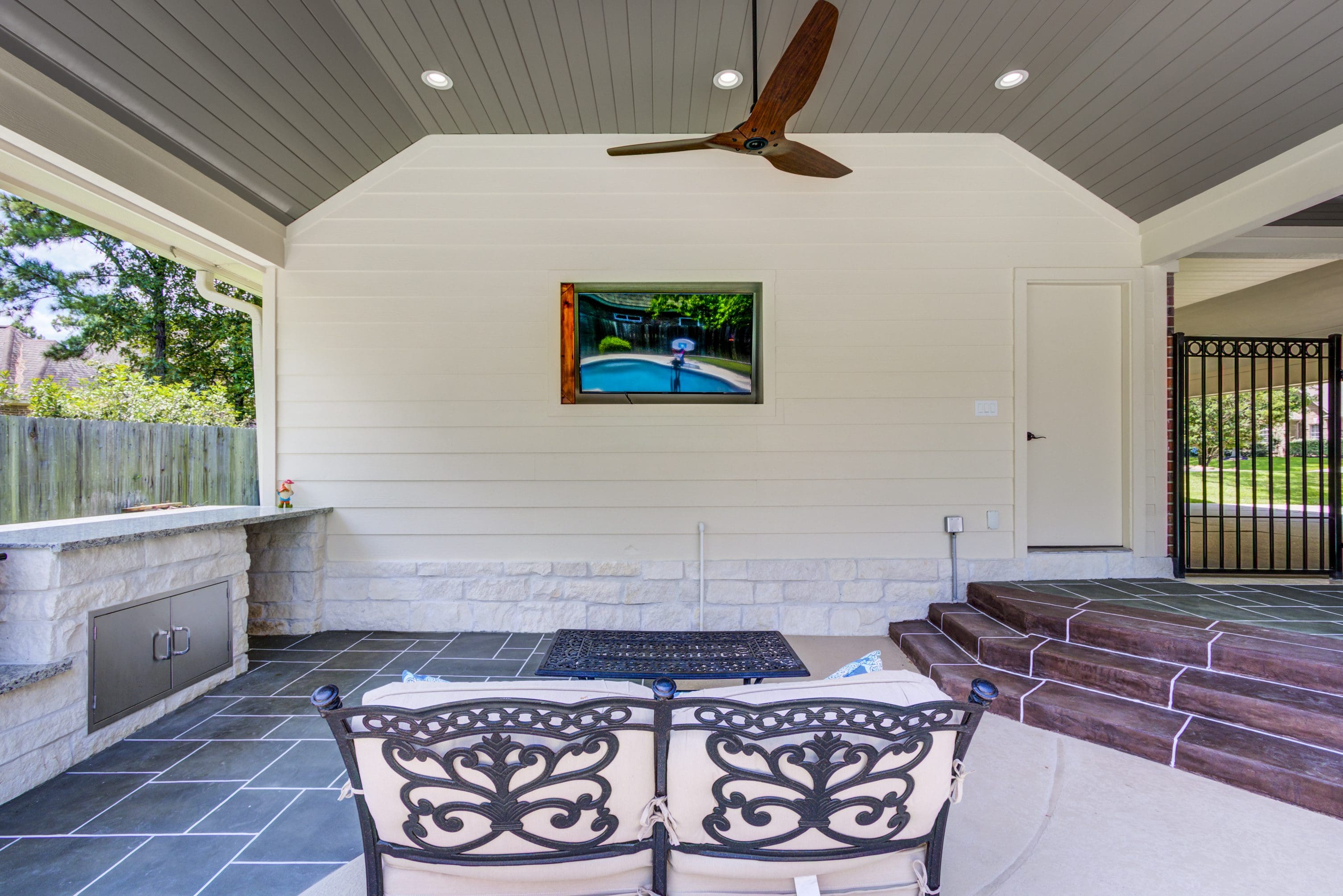 A room with two chairs and a pool in the background.