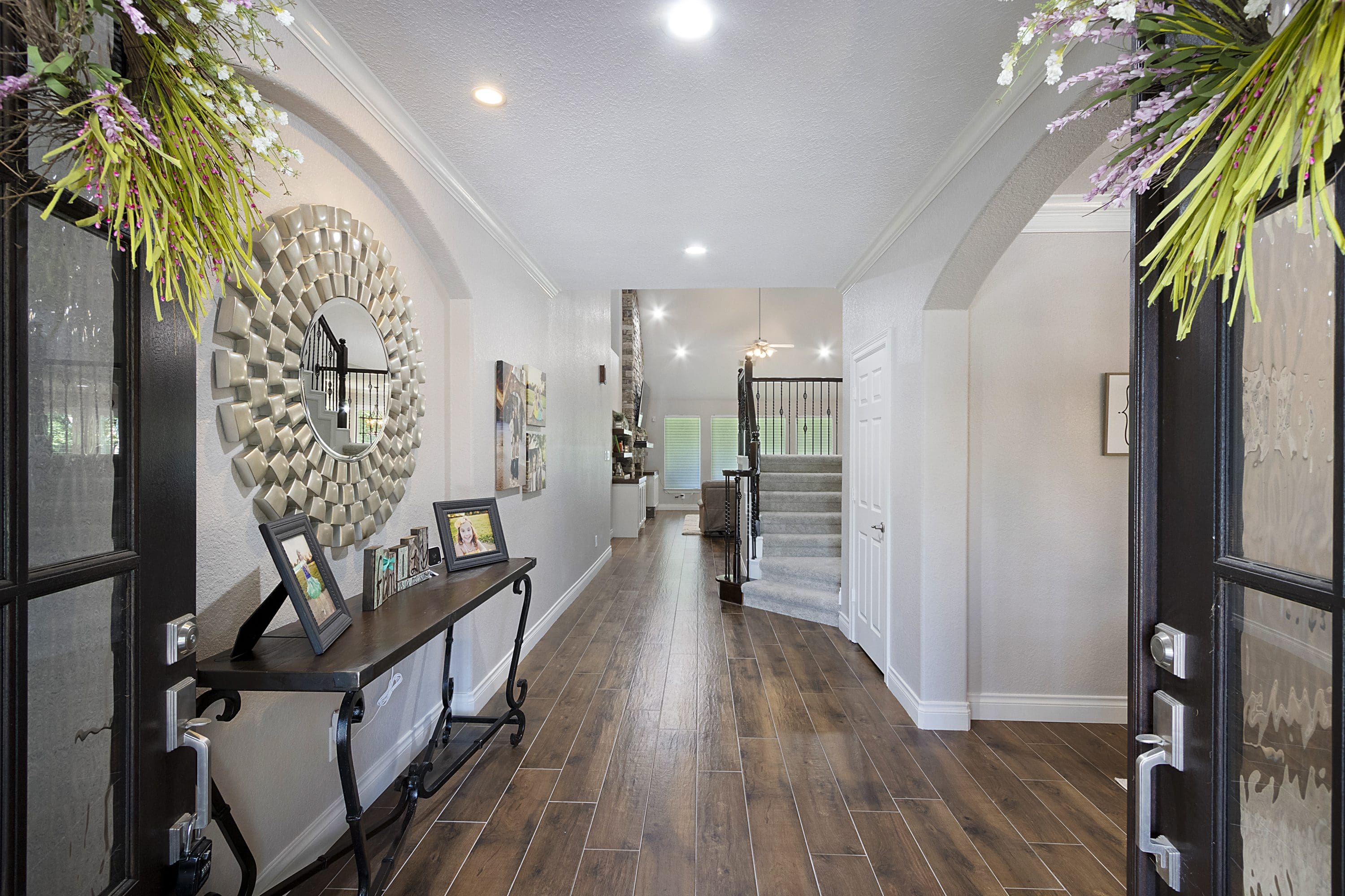 A hallway with wooden floors and white walls.