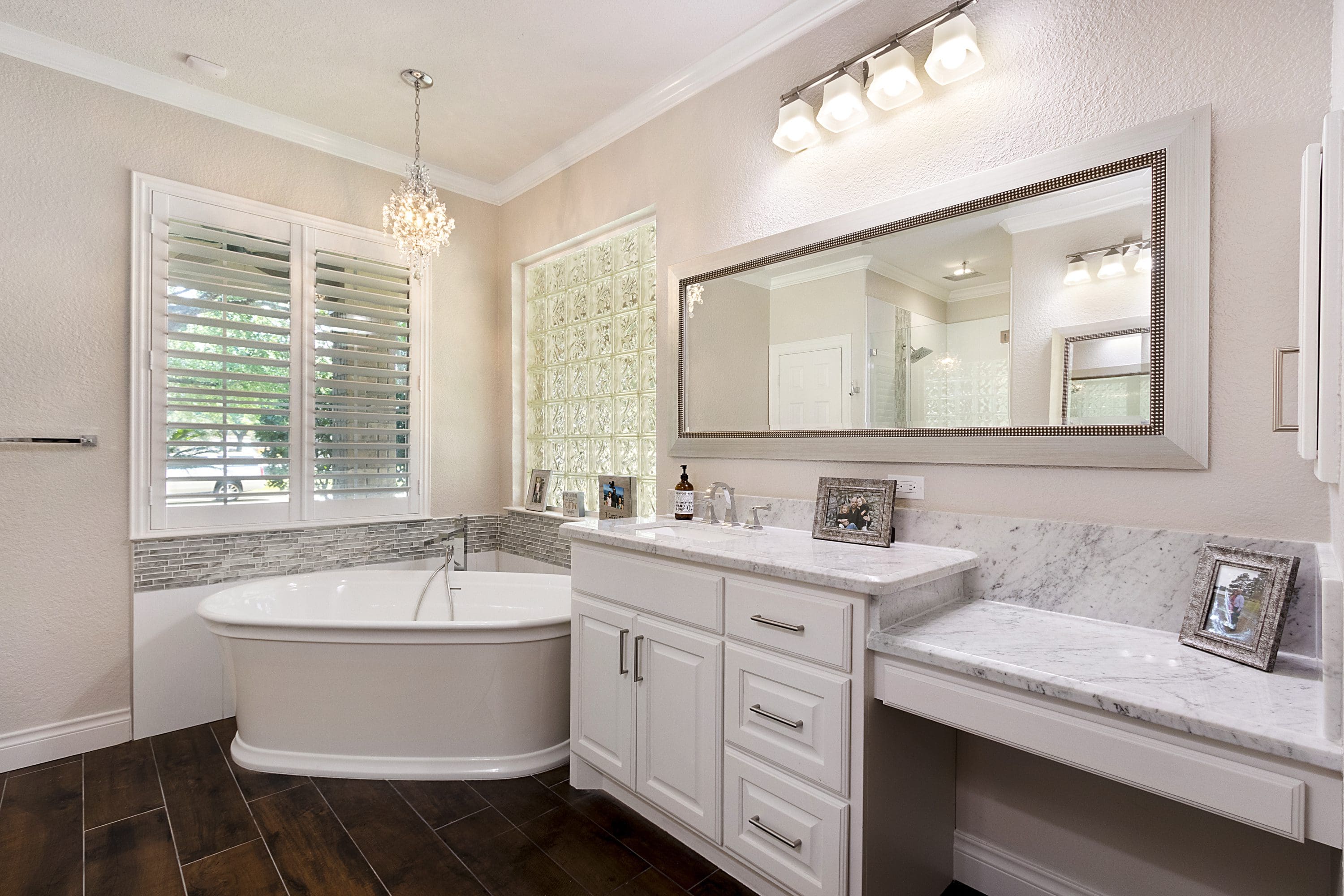 A bathroom with a large mirror and a tub.