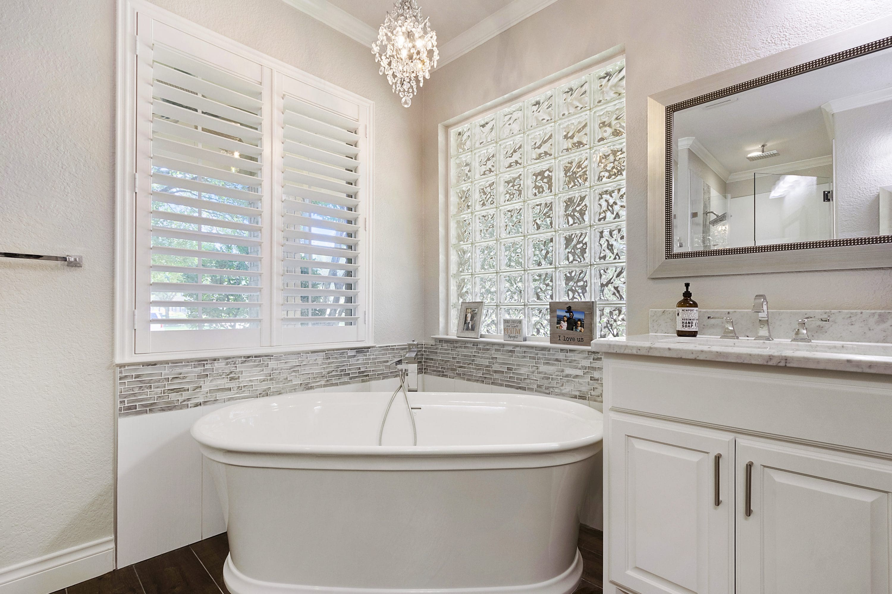 A bathroom with a large tub and sink.