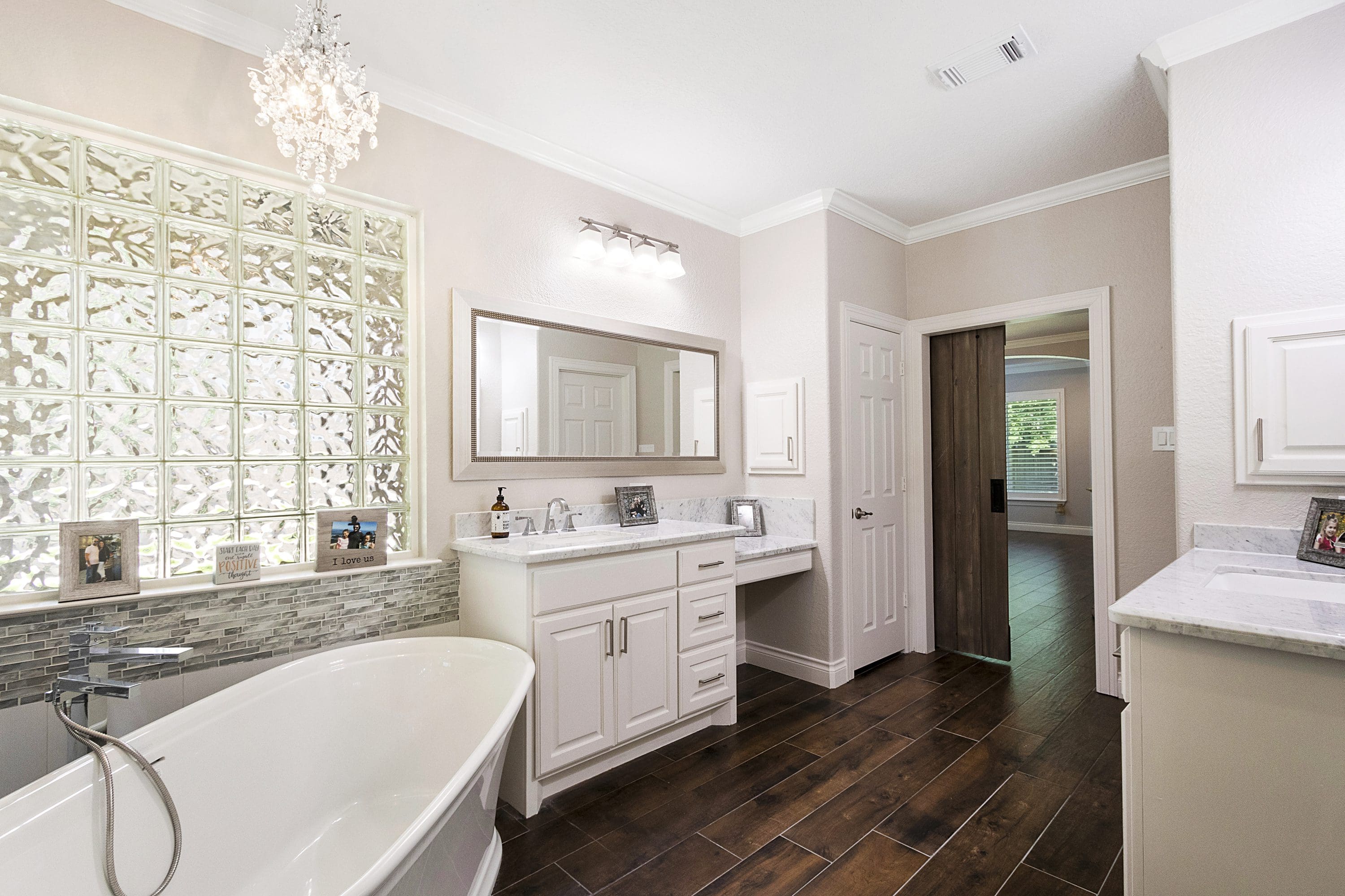 A bathroom with a large mirror and a tub.