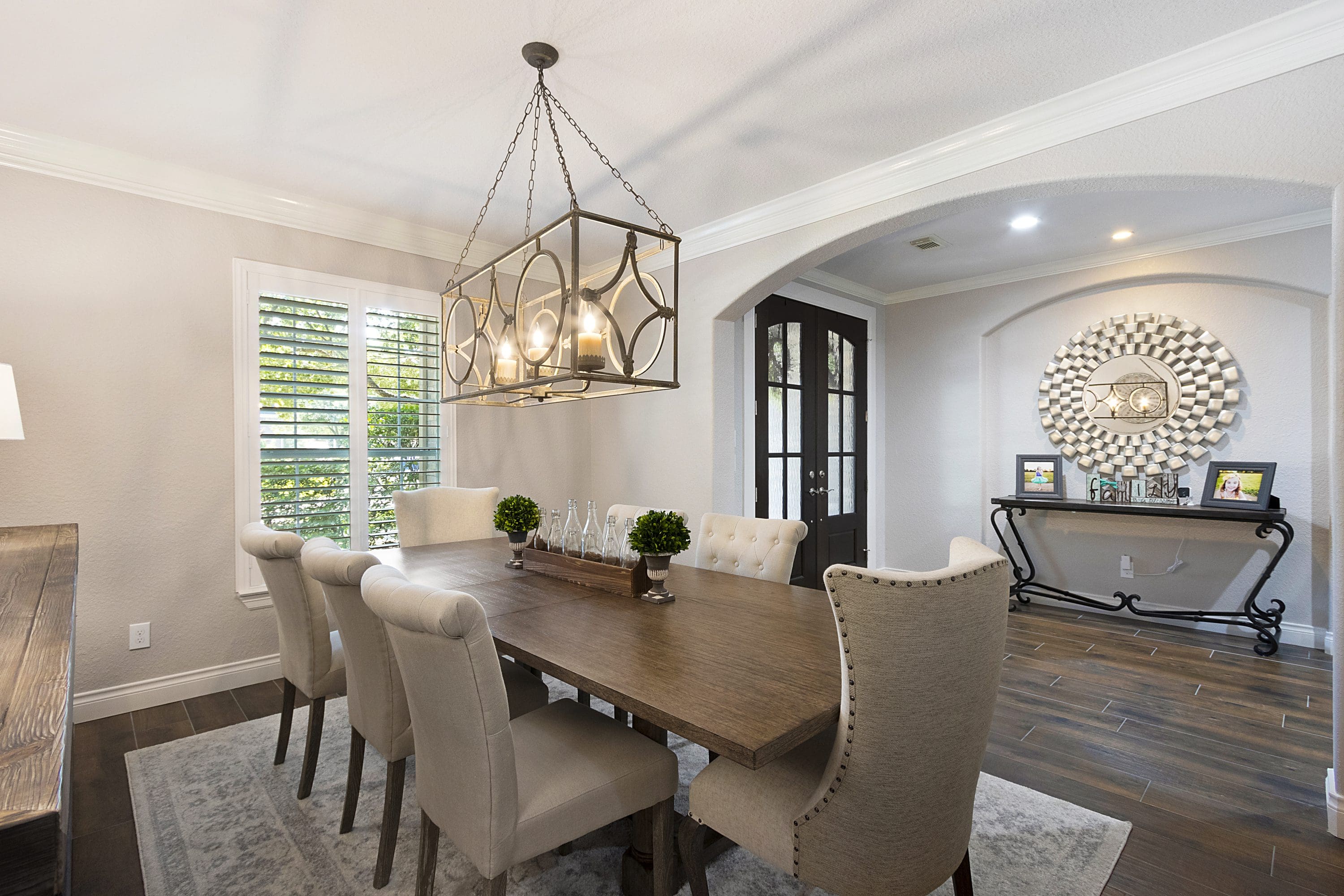 A dining room table with chairs and a chandelier.