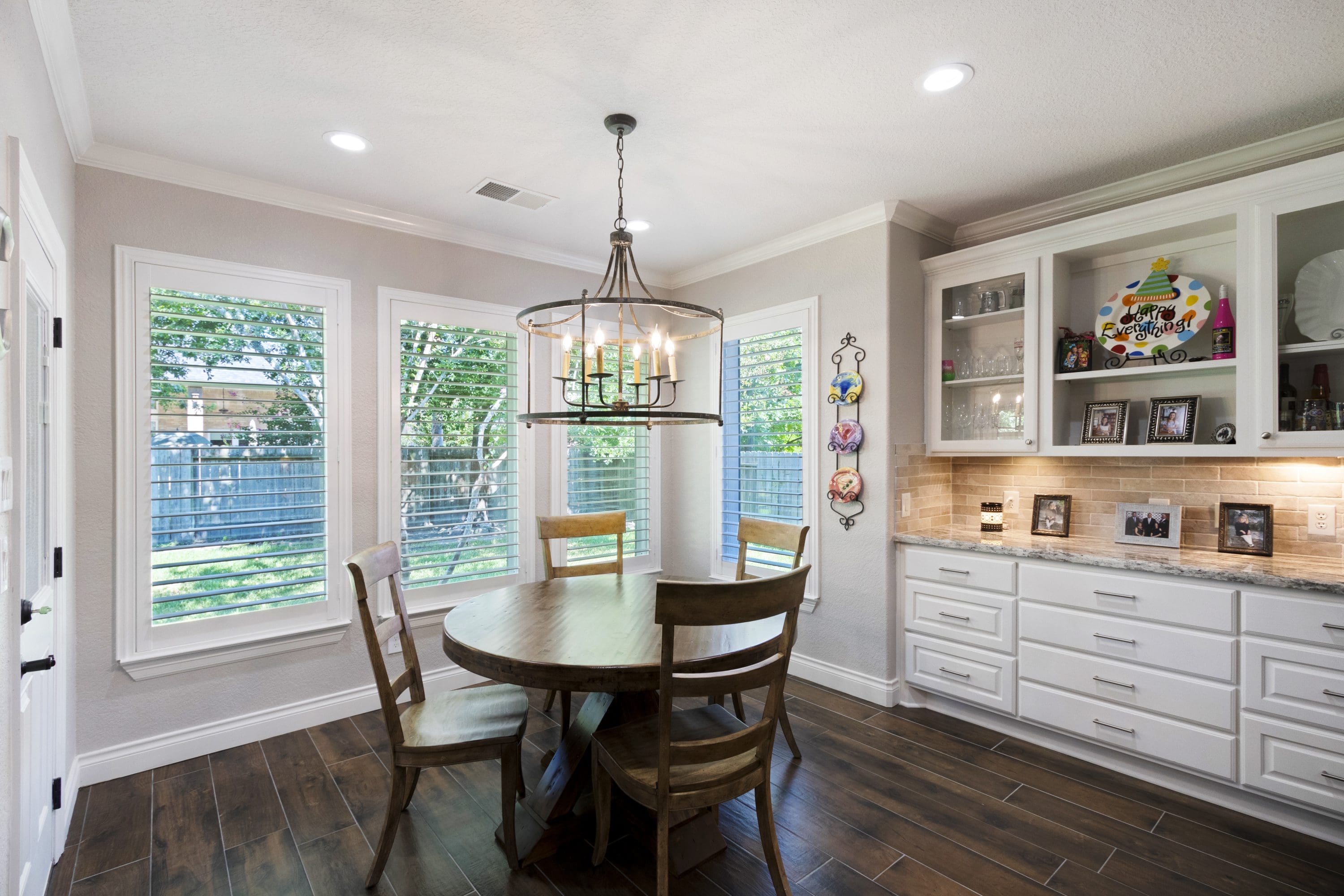 A dining room with wooden floors and white walls.