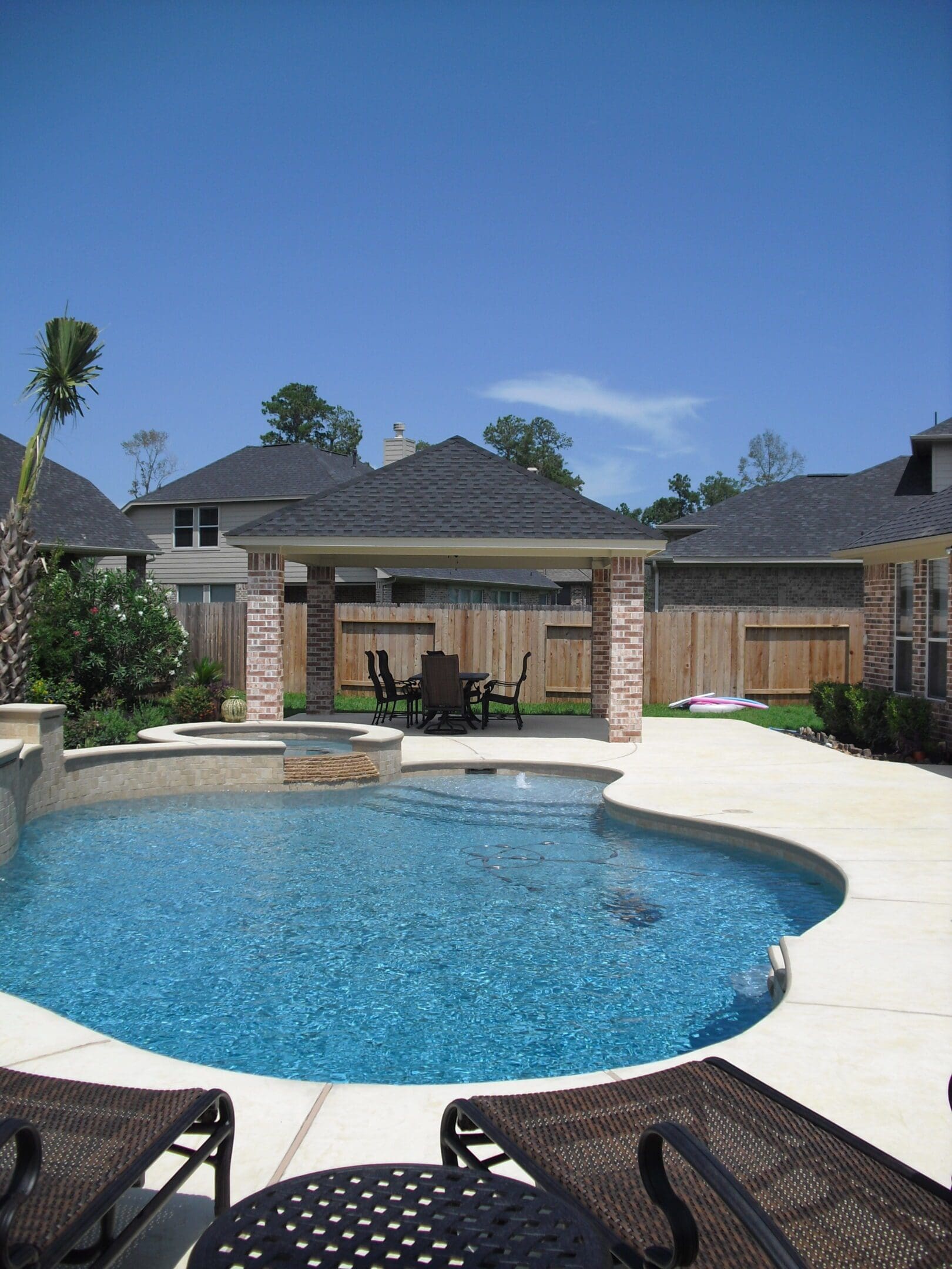 A pool with a gazebo and patio furniture.