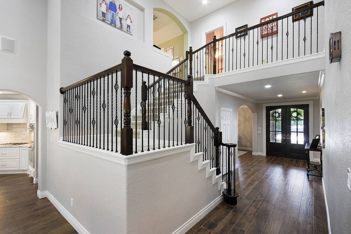 GettyImages-901157728-3 (2) A staircase with wood and metal railing in the middle of it.