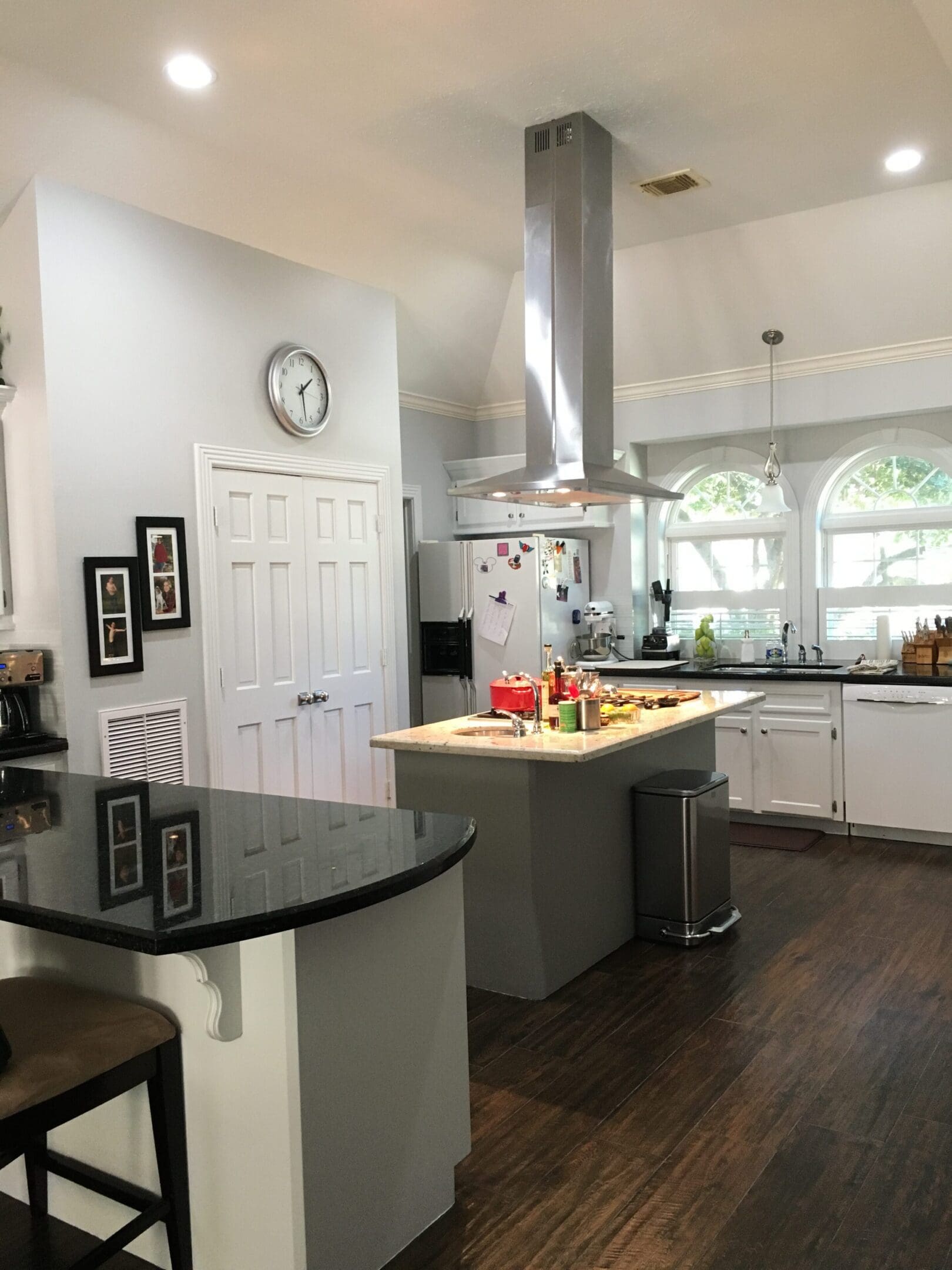 A kitchen with a large island and a black counter.