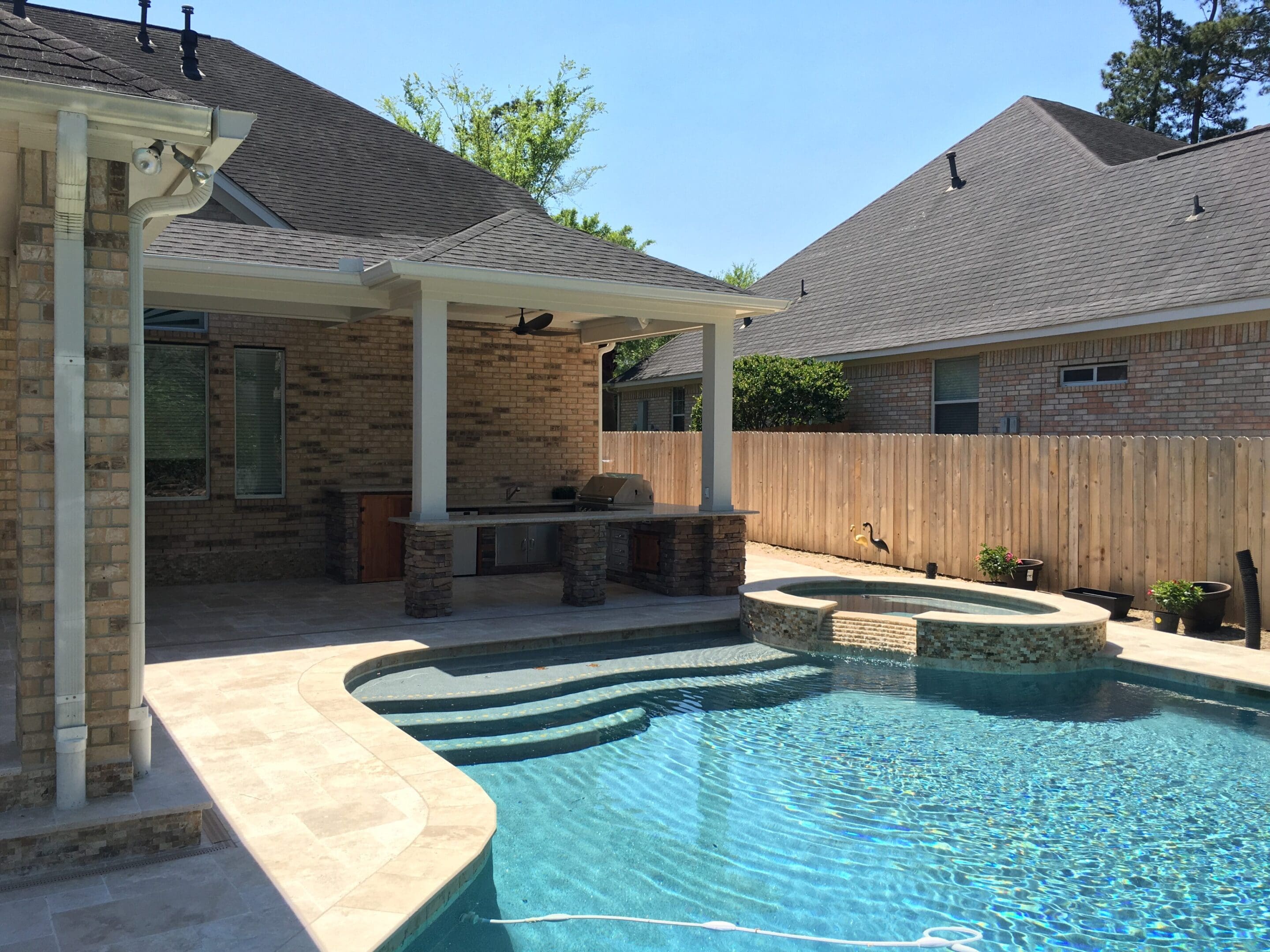 A pool with an outdoor fireplace and fire pit.