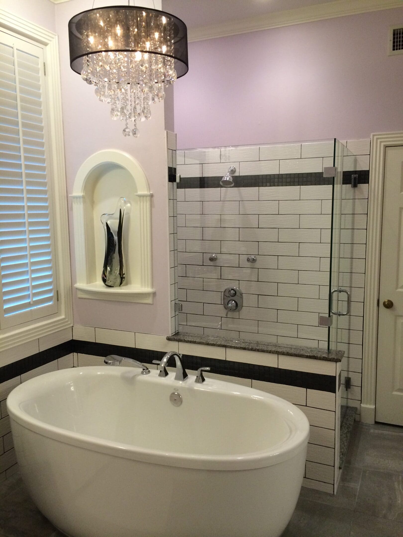 A bathroom with a tub, shower and window.