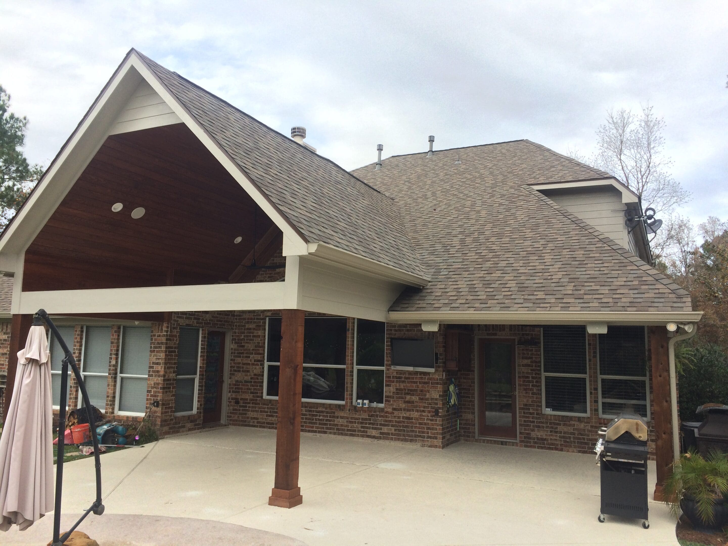A large house with a covered patio and barbecue grill.