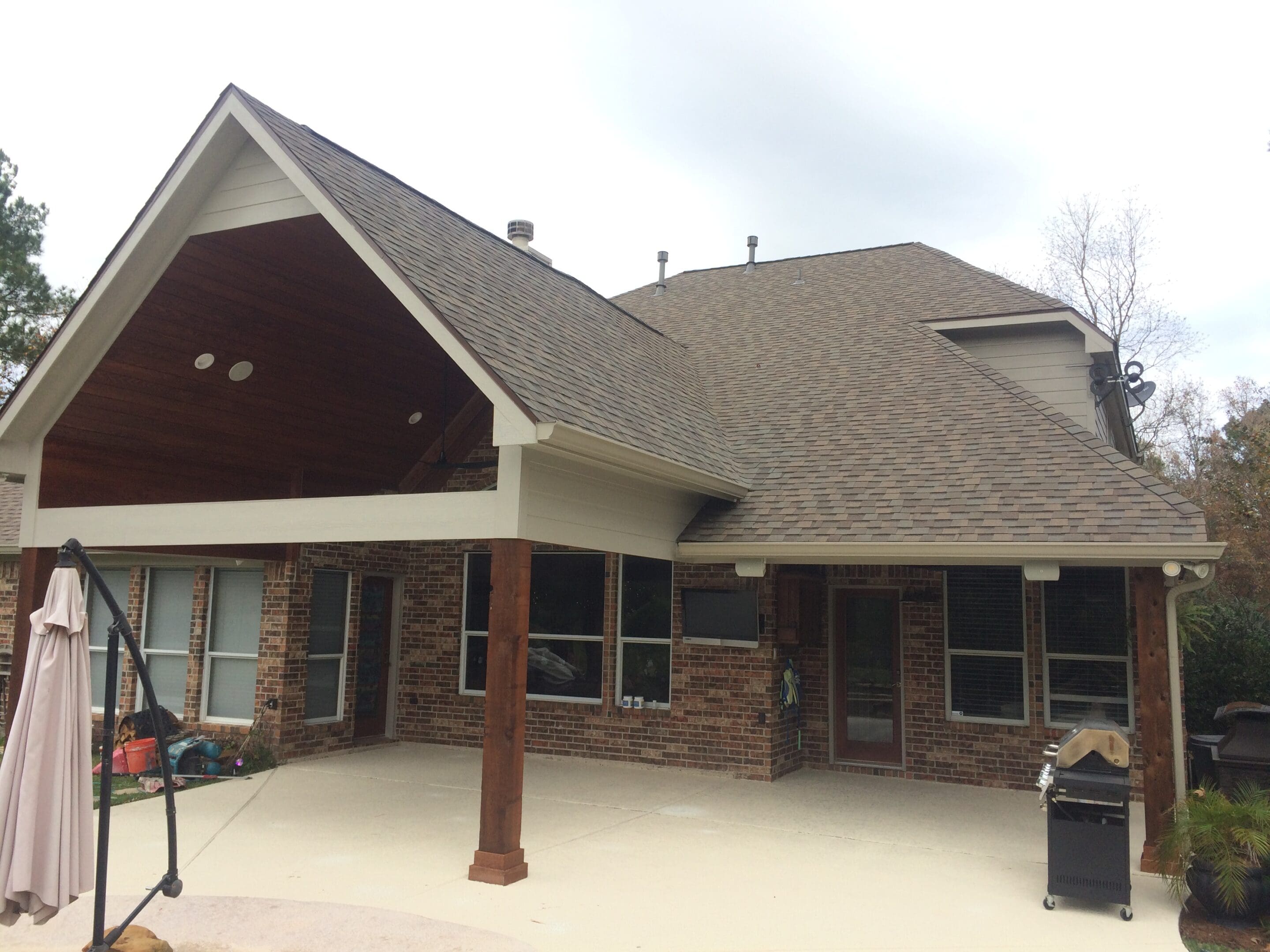 A large house with a covered patio and a fire pit.