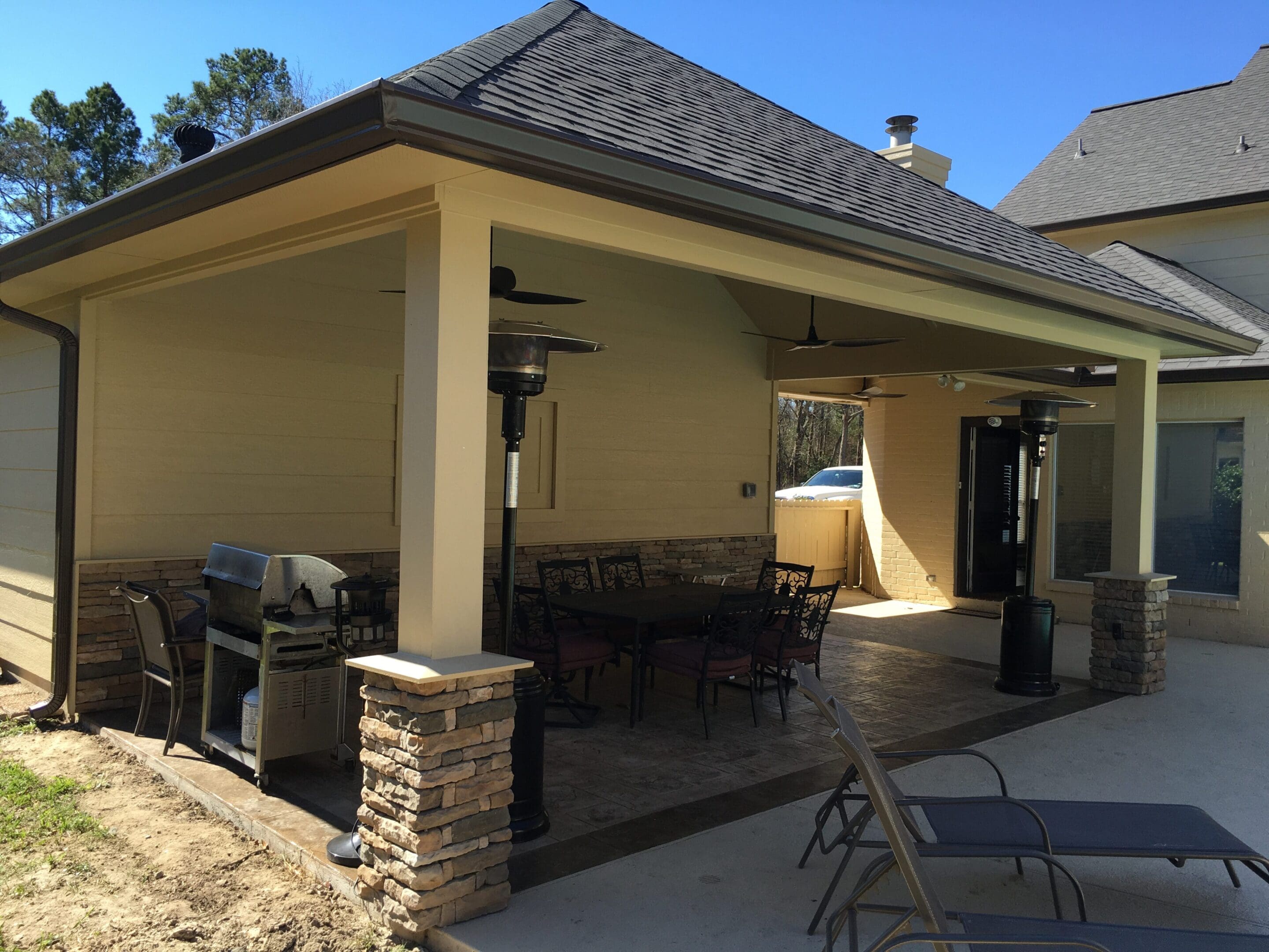 A patio with tables and chairs outside of the house.