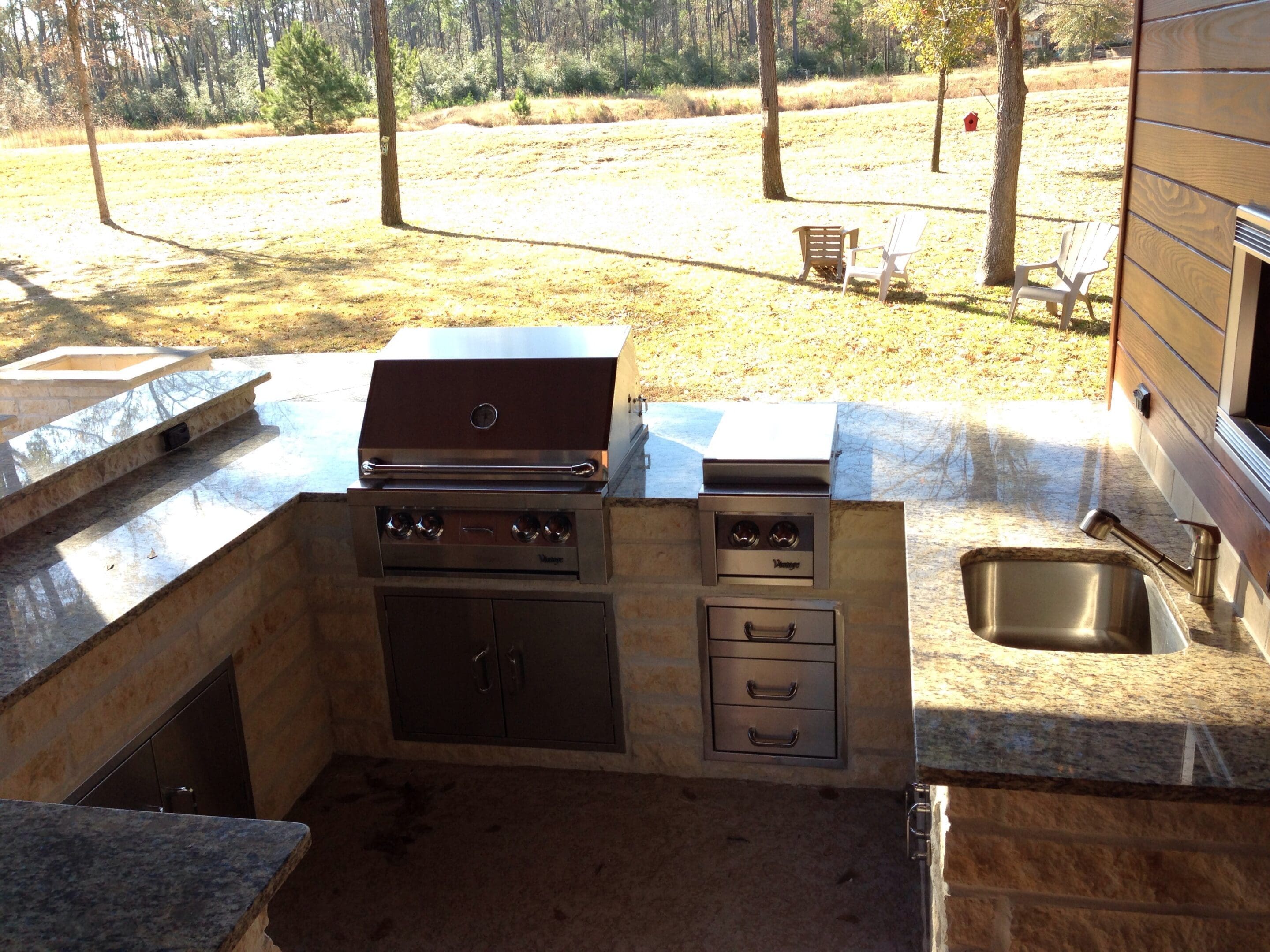 A large outdoor kitchen with an oven and sink.