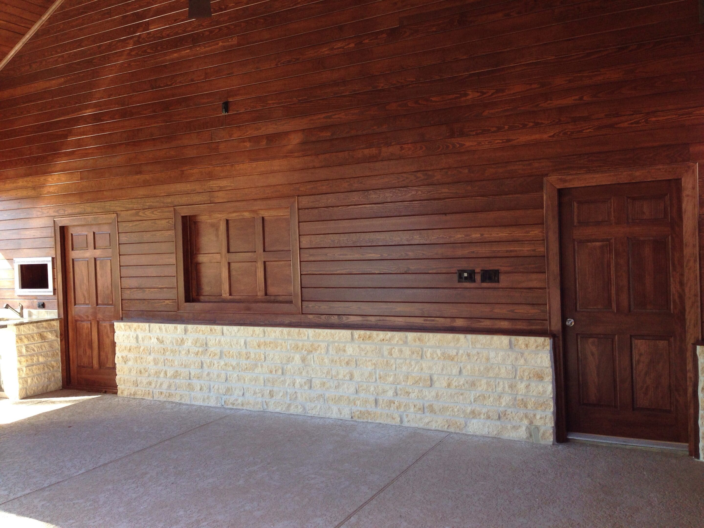 A room with wood paneling and stone flooring.