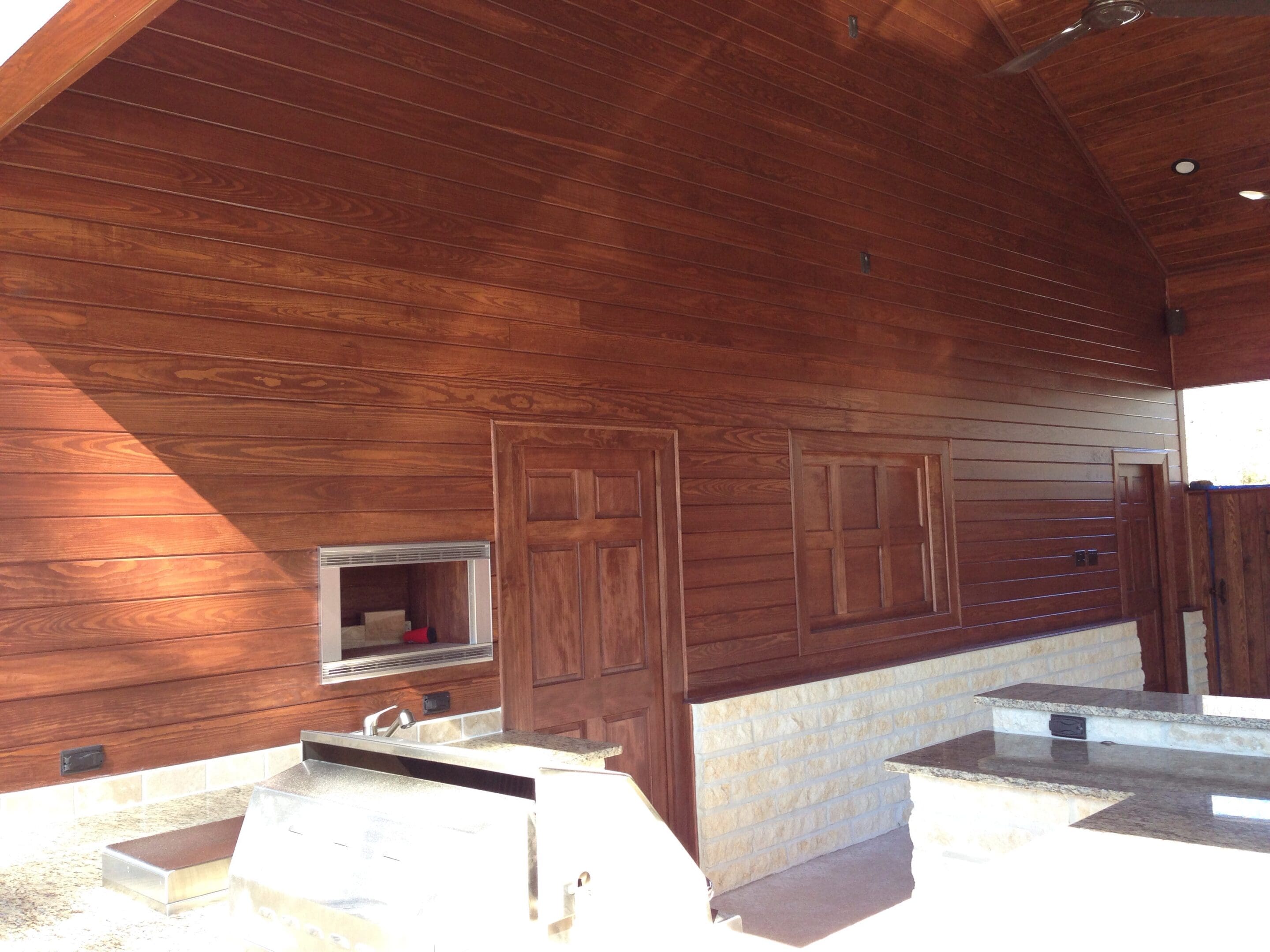 A room with wood paneling and a white wall.