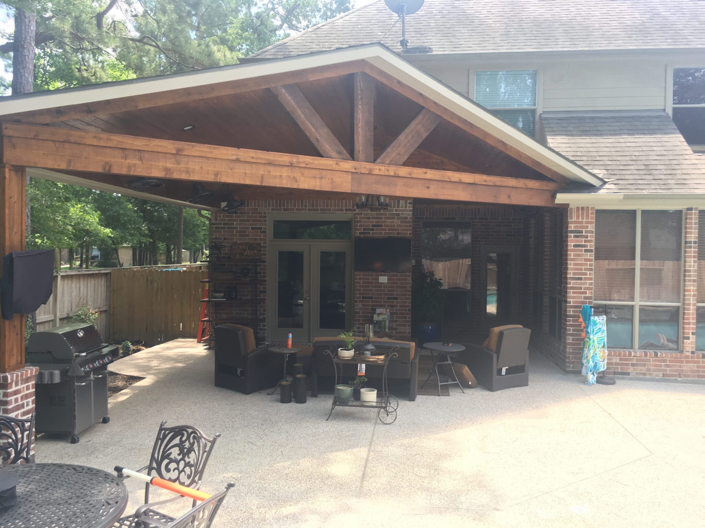 A patio with chairs and tables outside of it