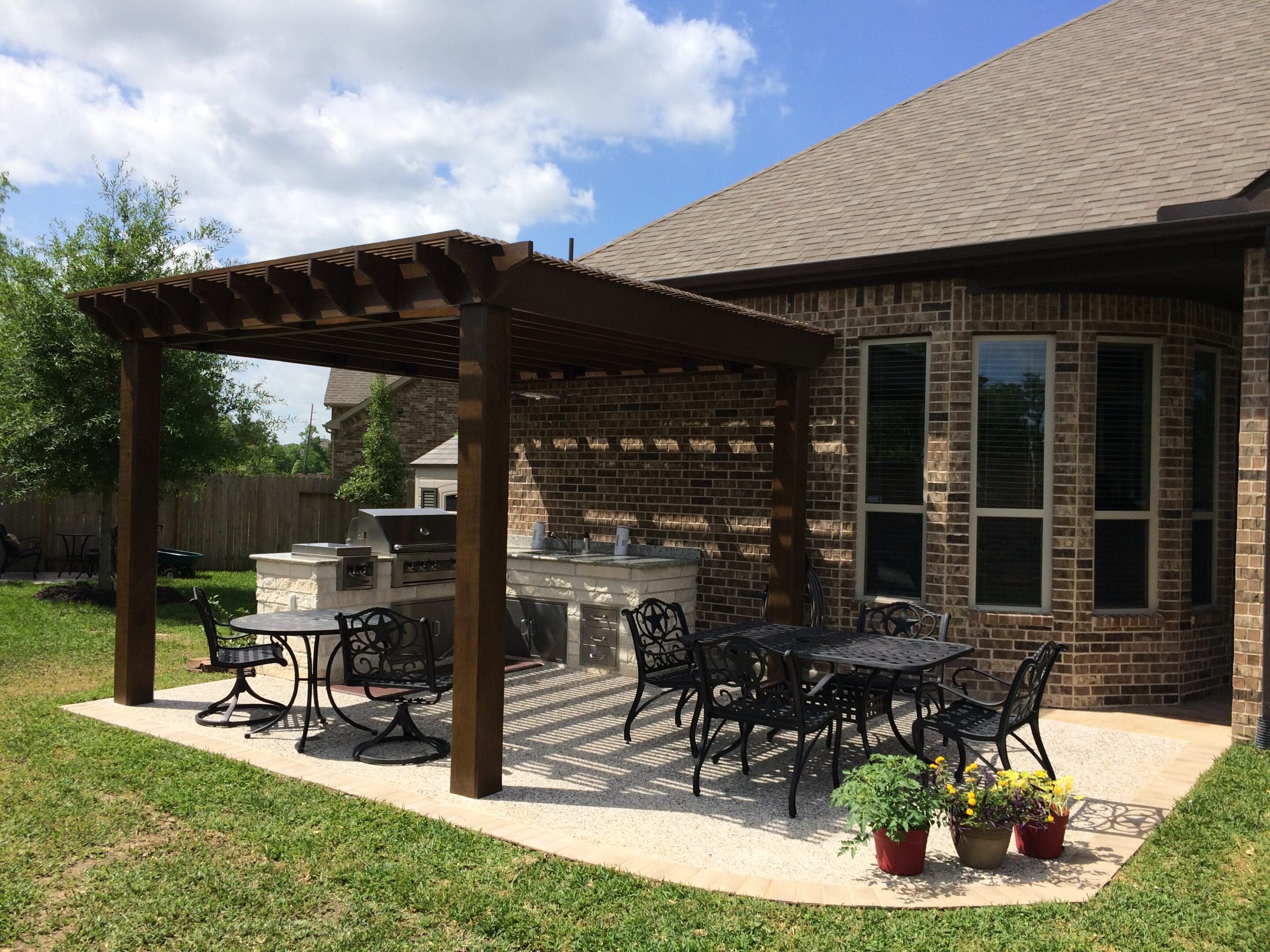 A patio with tables and chairs, grill and an outdoor fireplace.